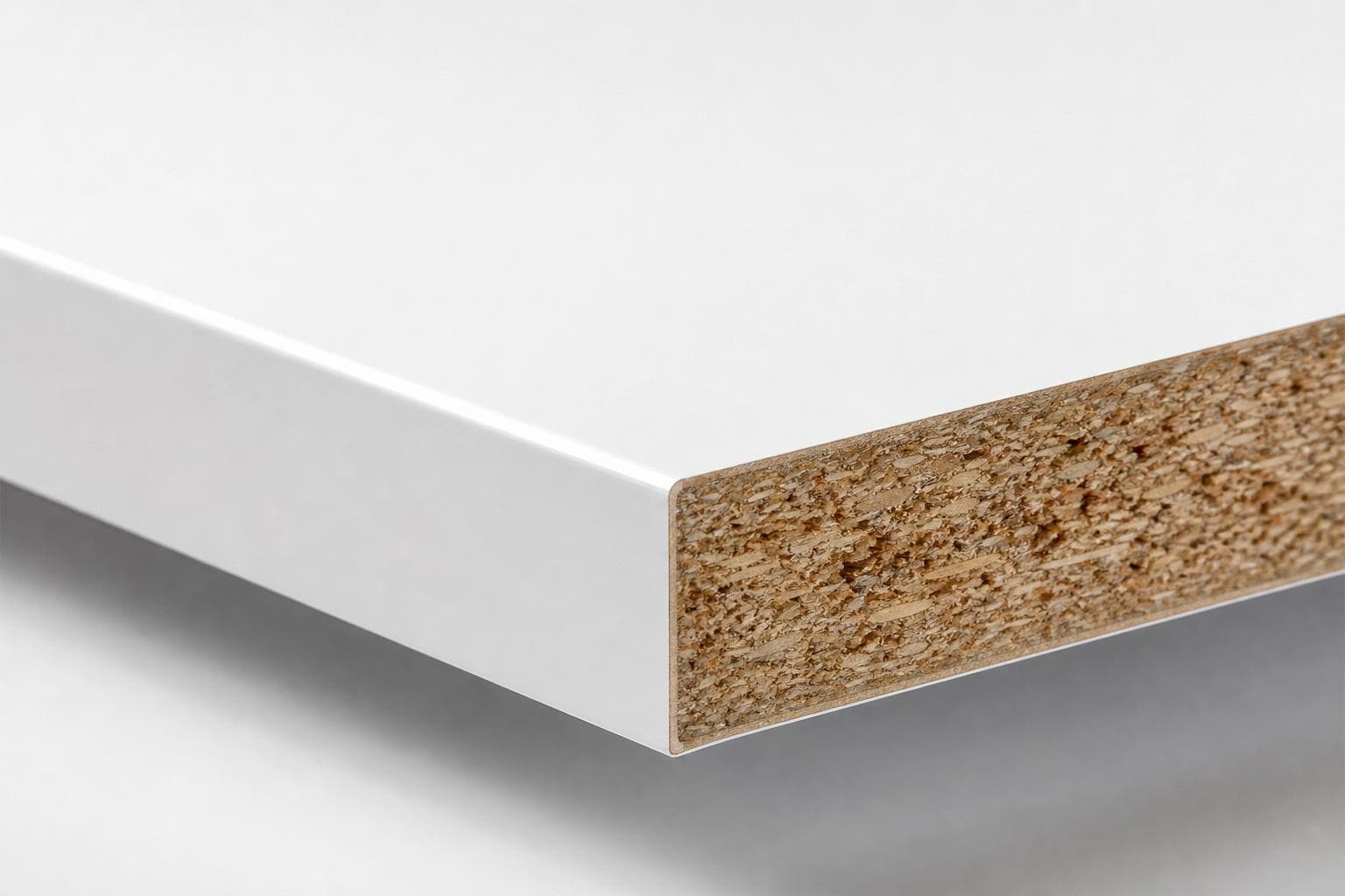 White melamine board with a smooth white face and edge, cut end showing the particleboard core